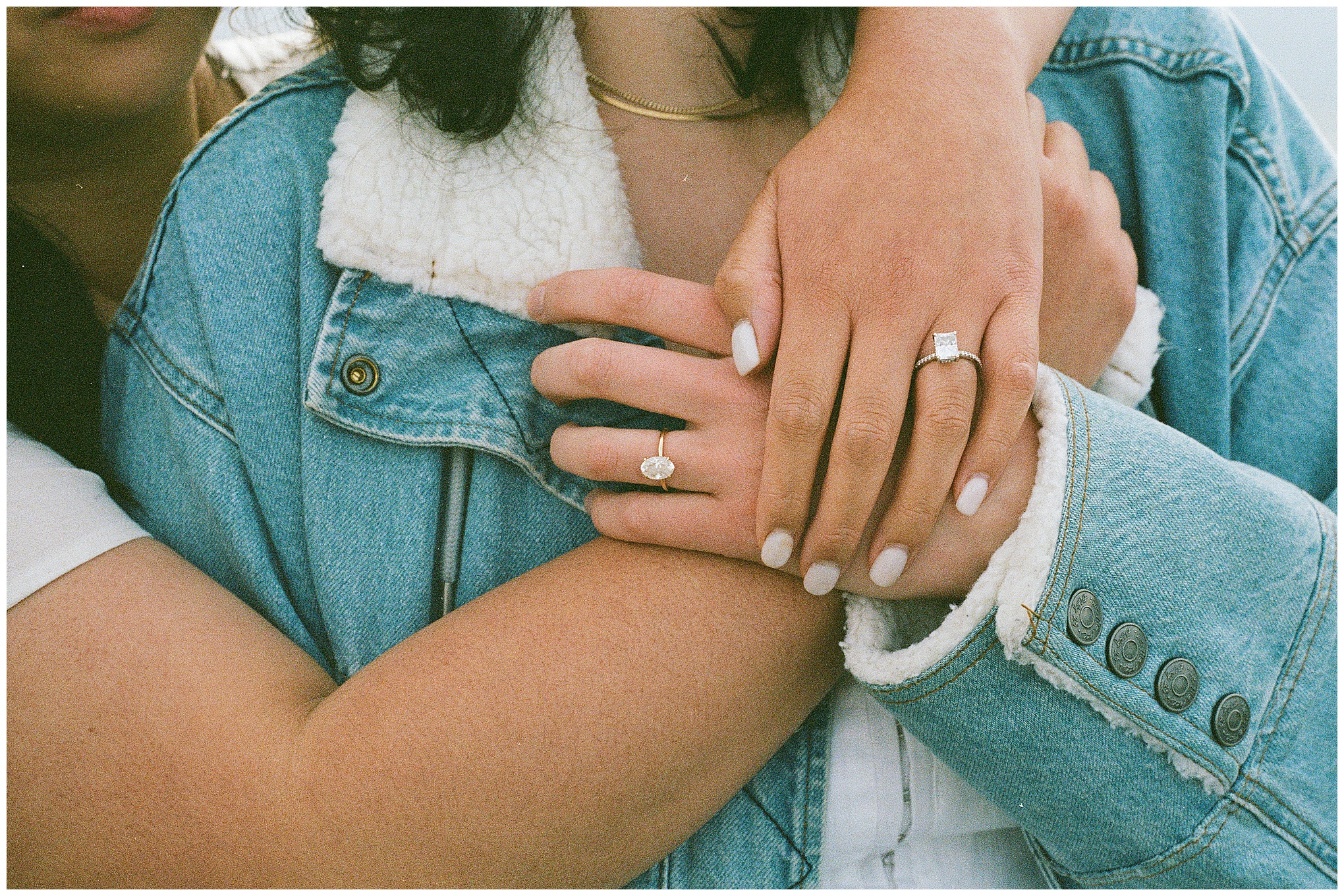 Close-up of Carli and Erin’s hands with engagement rings.