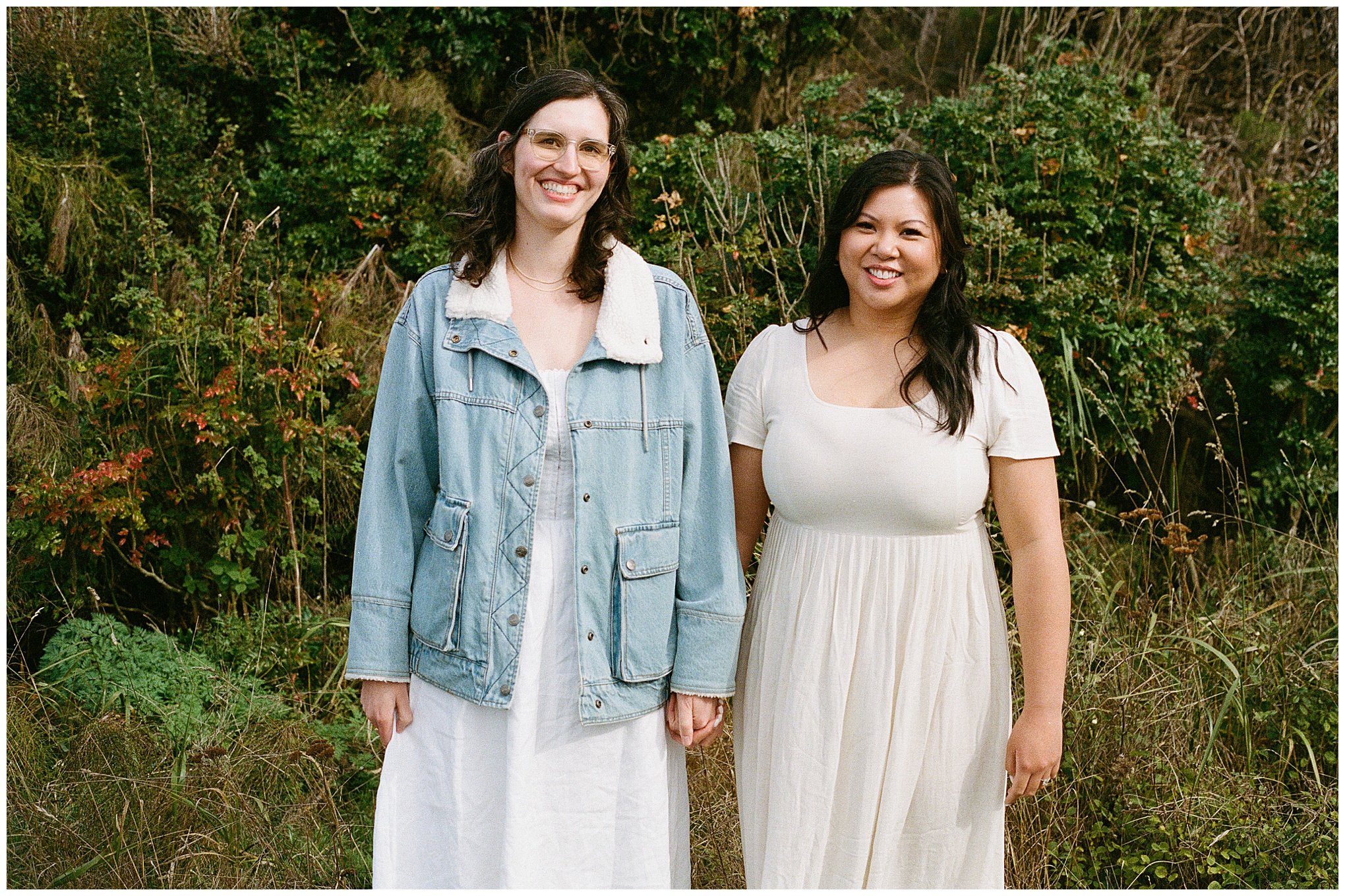 Carli and Erin standing together and smiling in a green area.