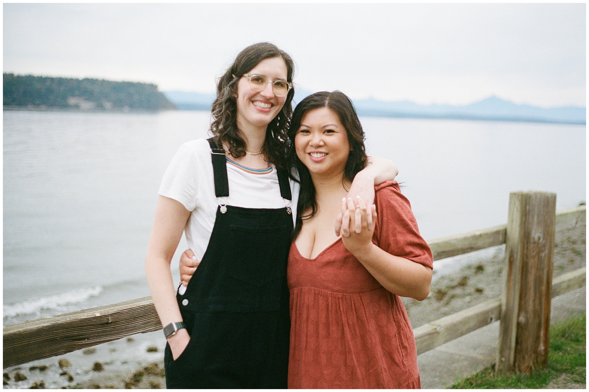 Couple holding hands and smiling by the water