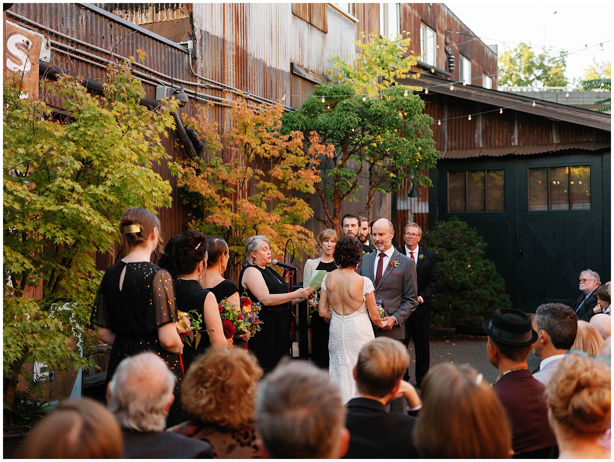 Bride and groom holding hands as they face the officiant during the ceremony.