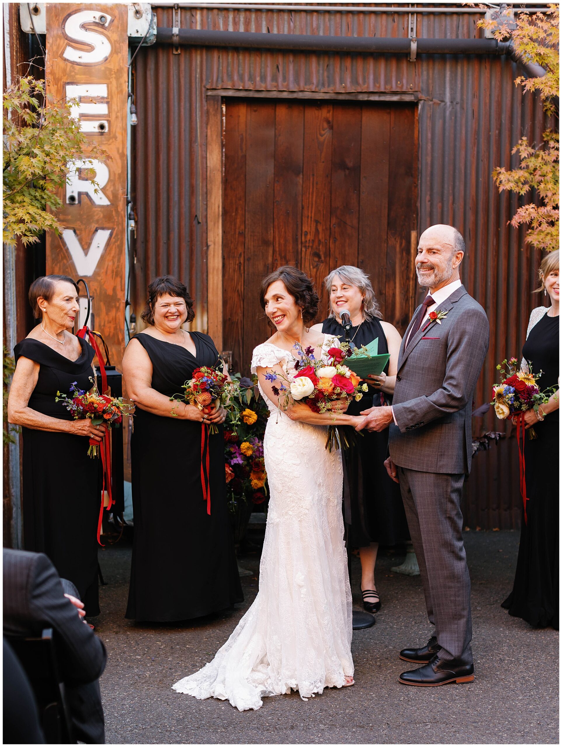 Bride smiling brightly at the groom during their wedding ceremony.