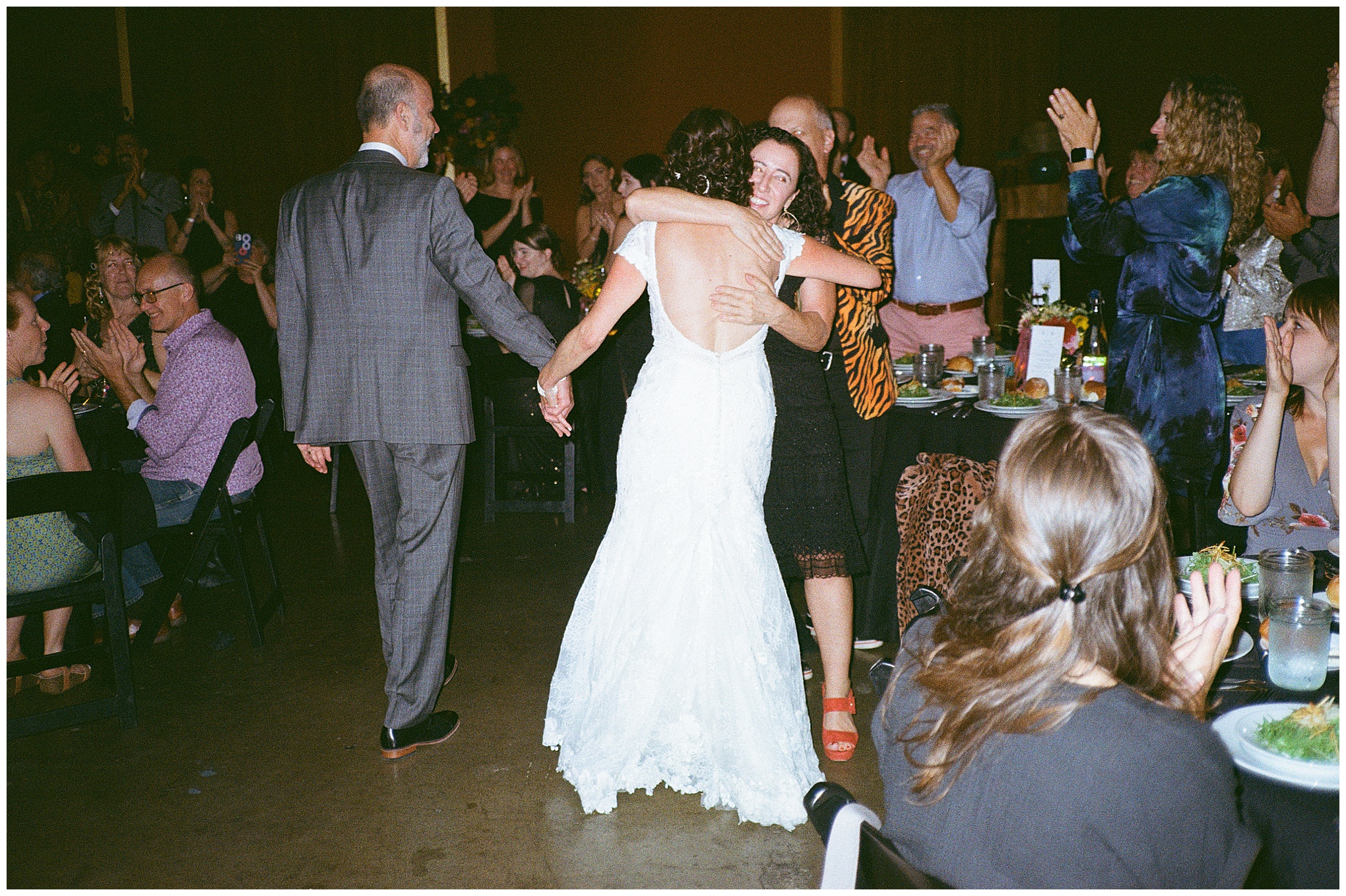 Bride and groom entering the reception hall to cheers and applause.