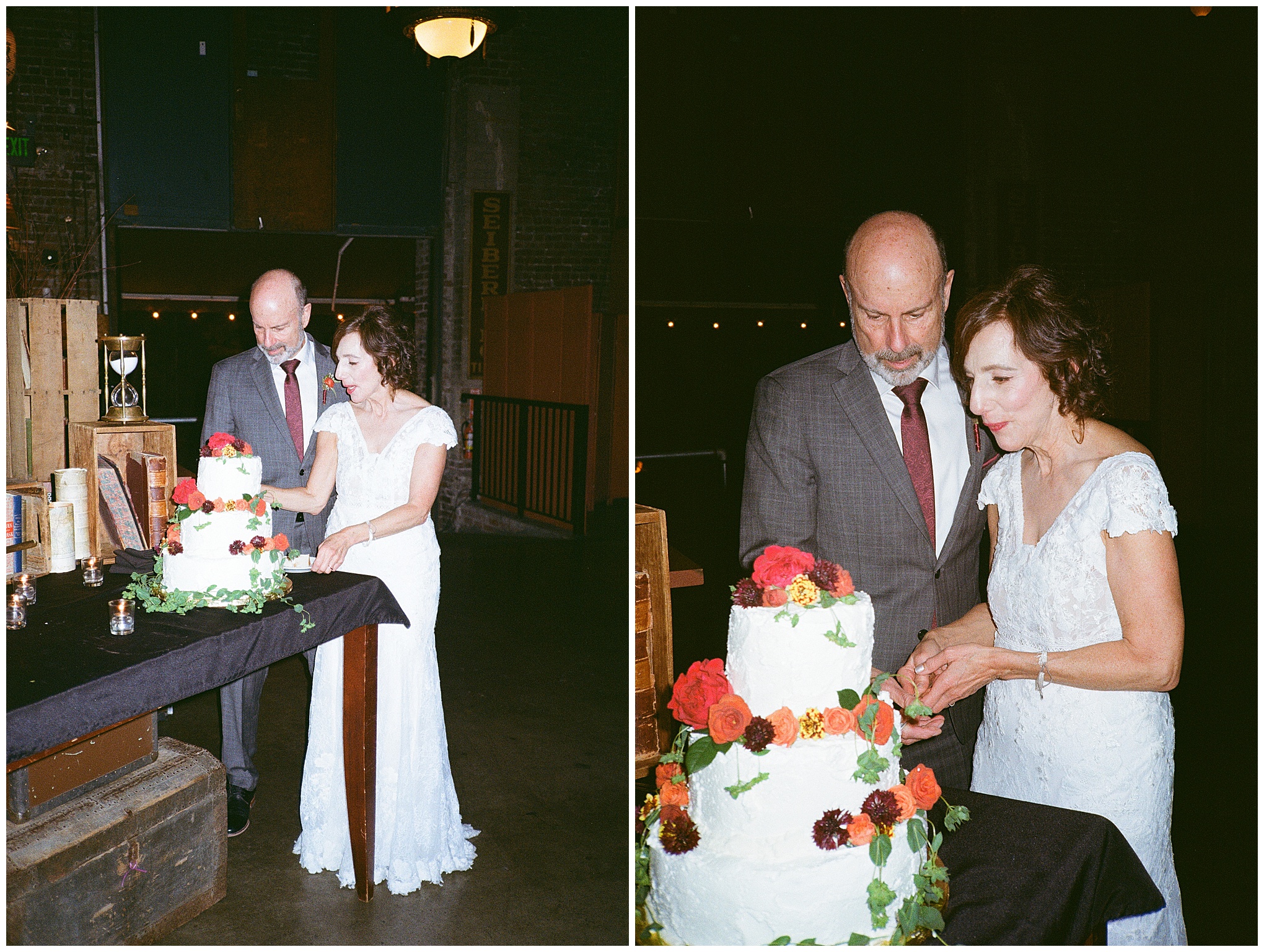 Bride and groom cutting their wedding cake adorned with red and orange flowers.