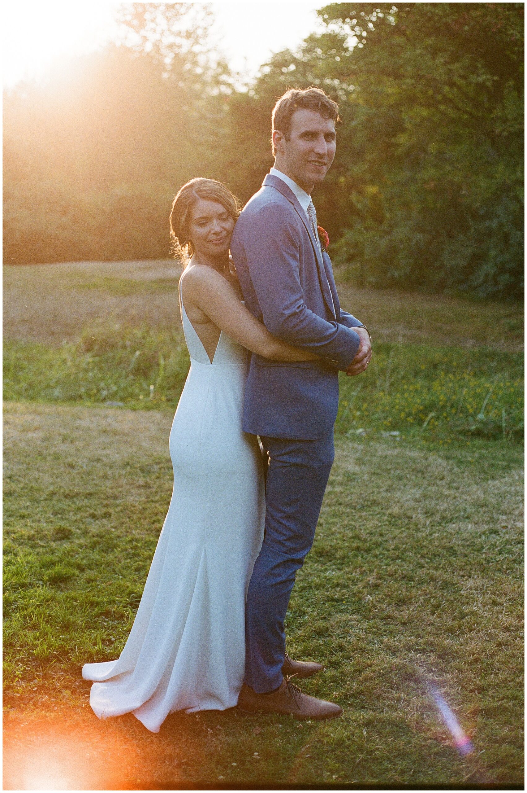 Grace and Chris embracing in a field during sunset at the Center for Urban Horticulture.