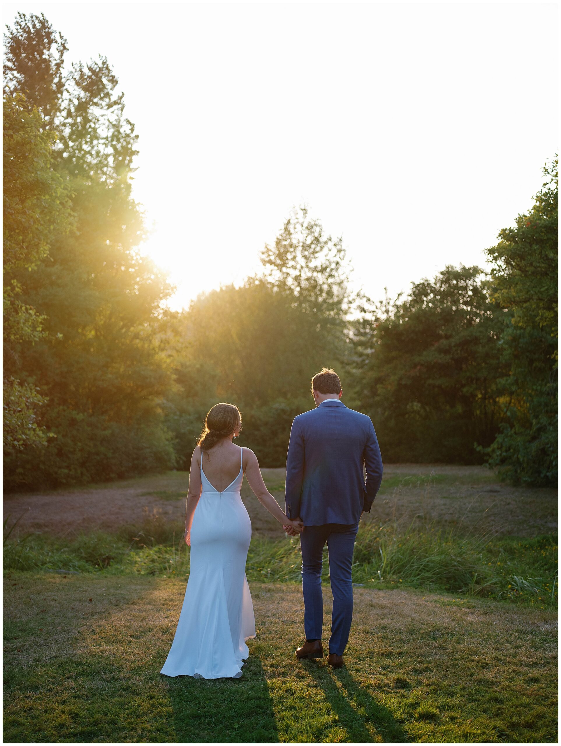 Grace and Chris walking hand-in-hand into the sunset at the Center for Urban Horticulture.