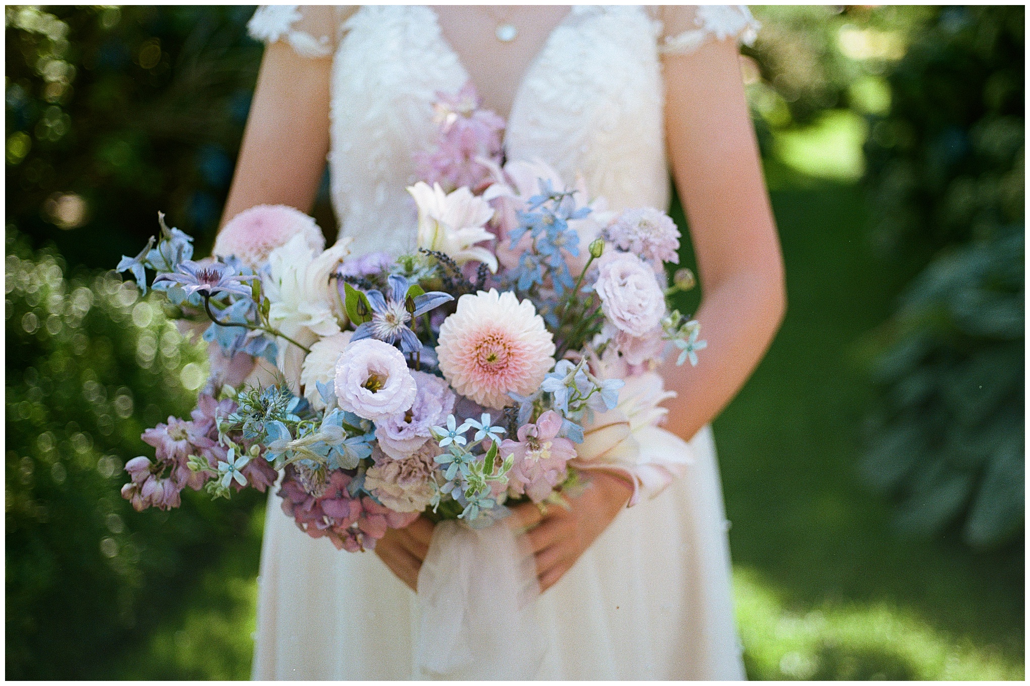 Close-up of the bride's pastel floral bouquet with dahlias and delphiniums.