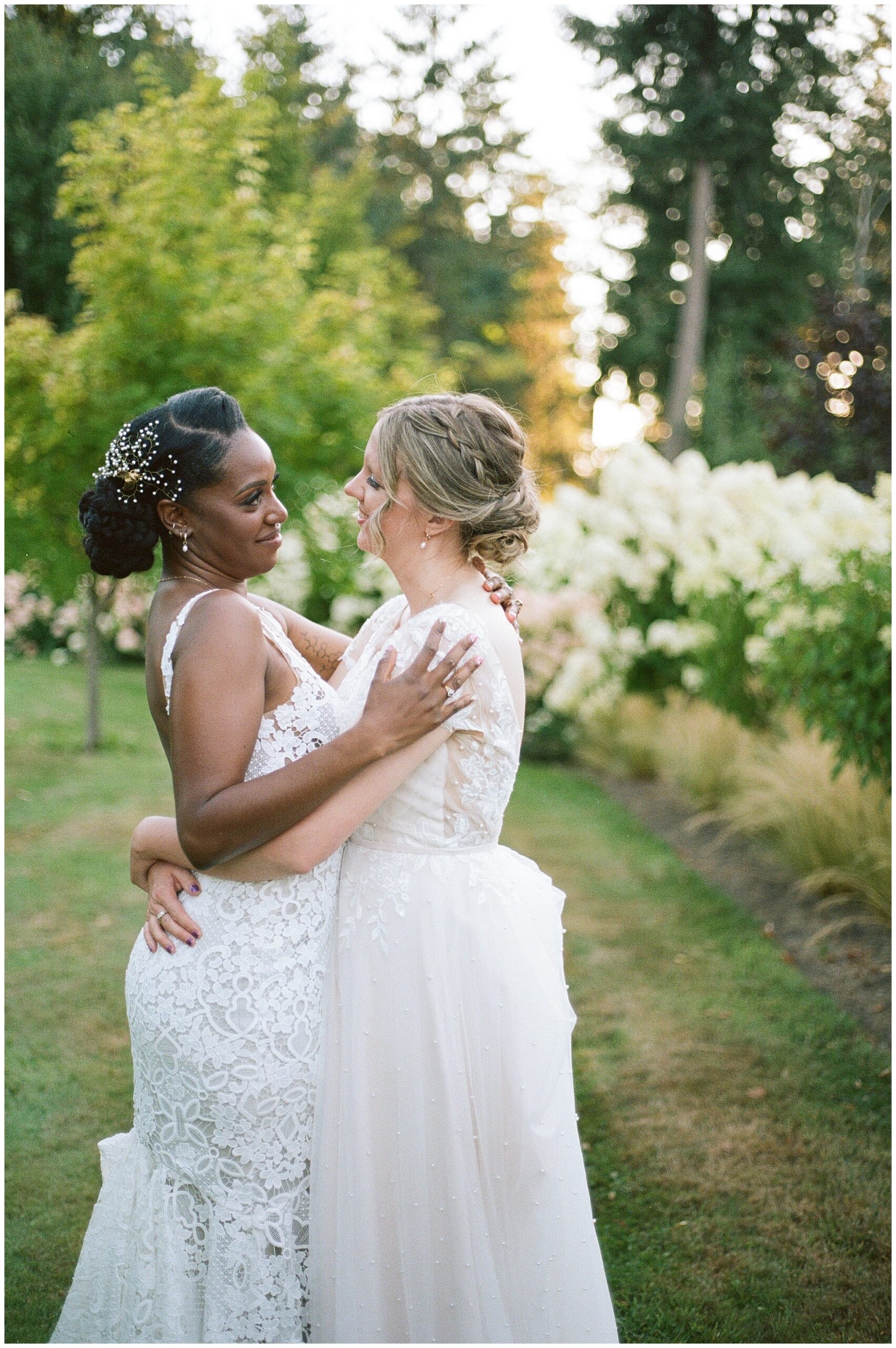 Brides sharing a romantic embrace in the garden.