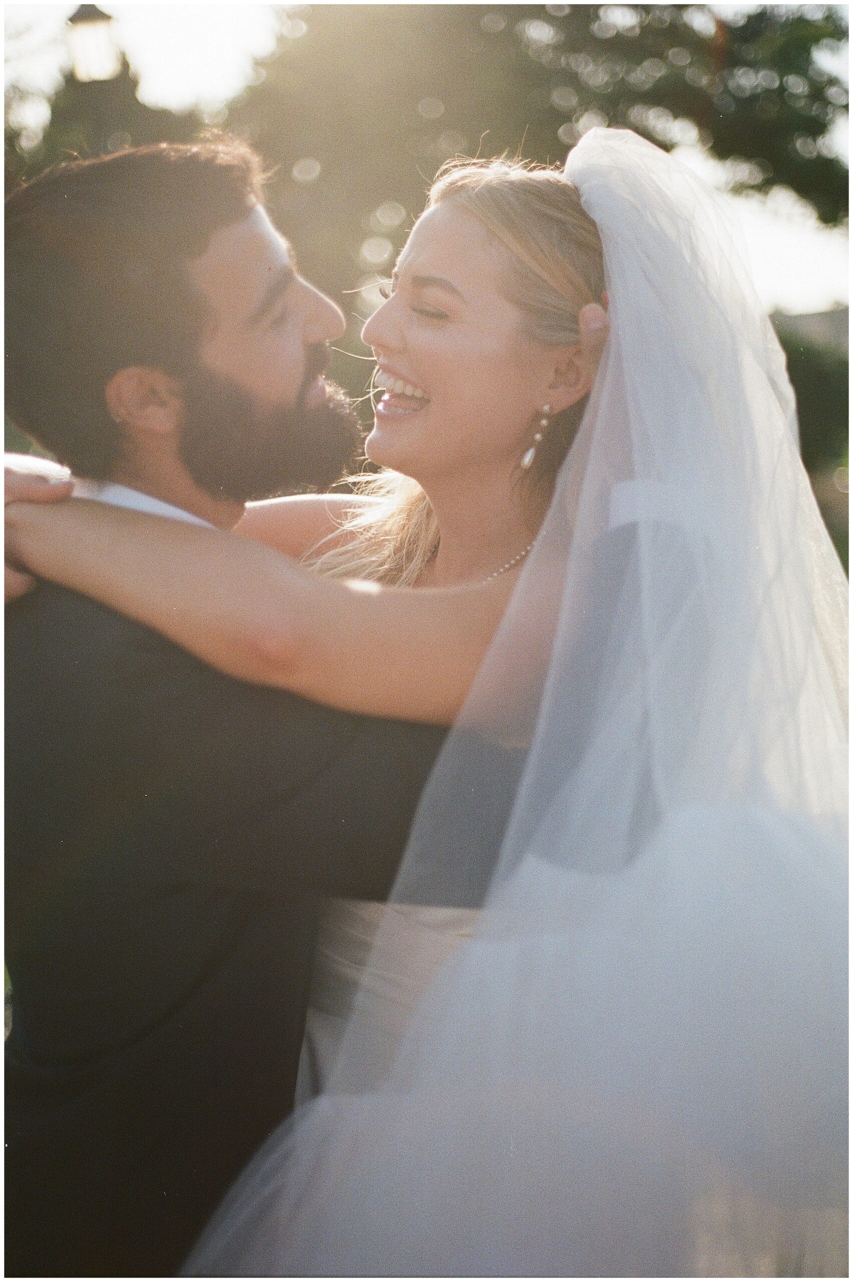 Bride and groom laughing together, sharing a joyful moment during their wedding.