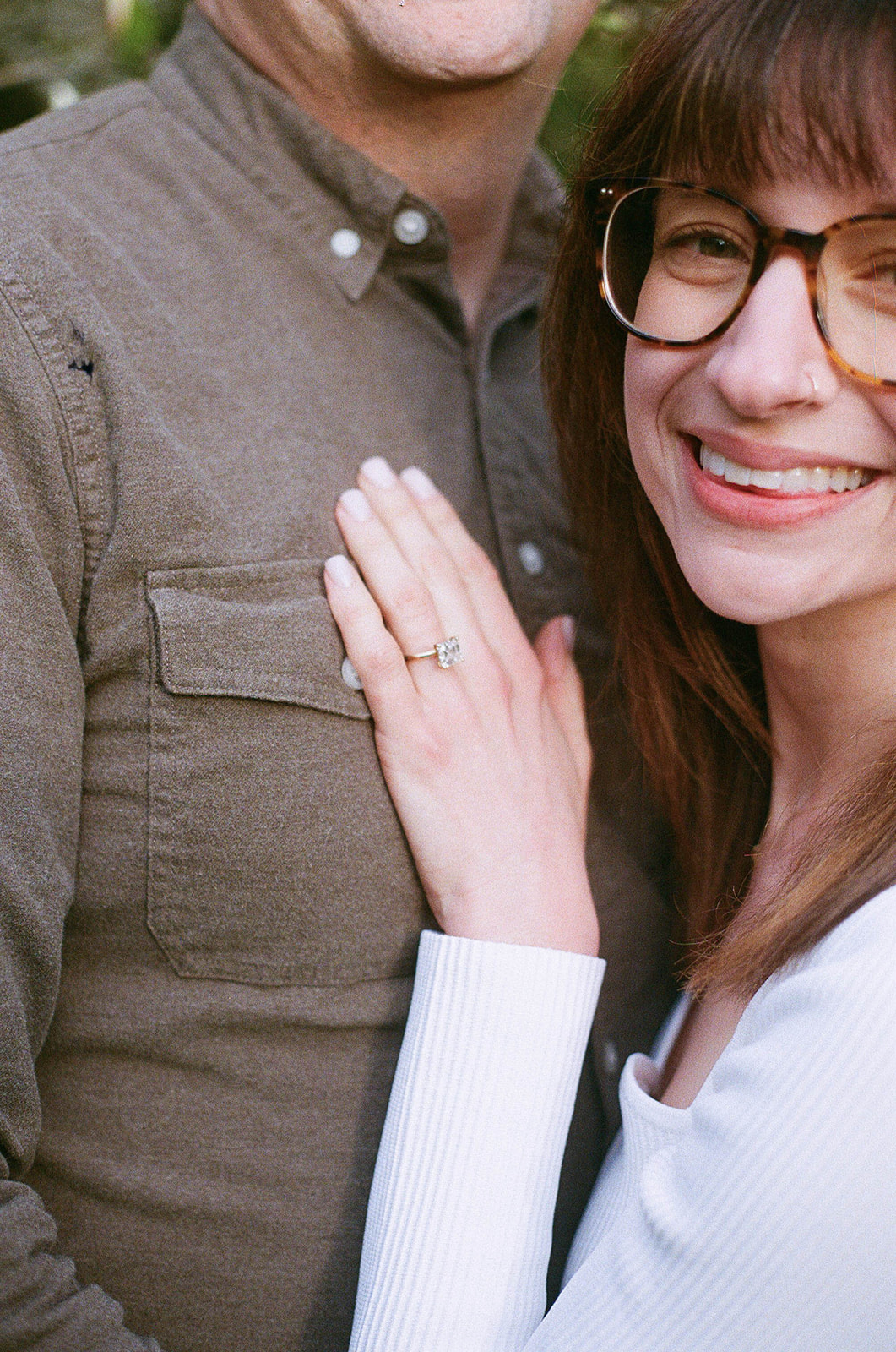 Close-up of Charlotte’s engagement ring as she rests her hand on Grant’s chest.