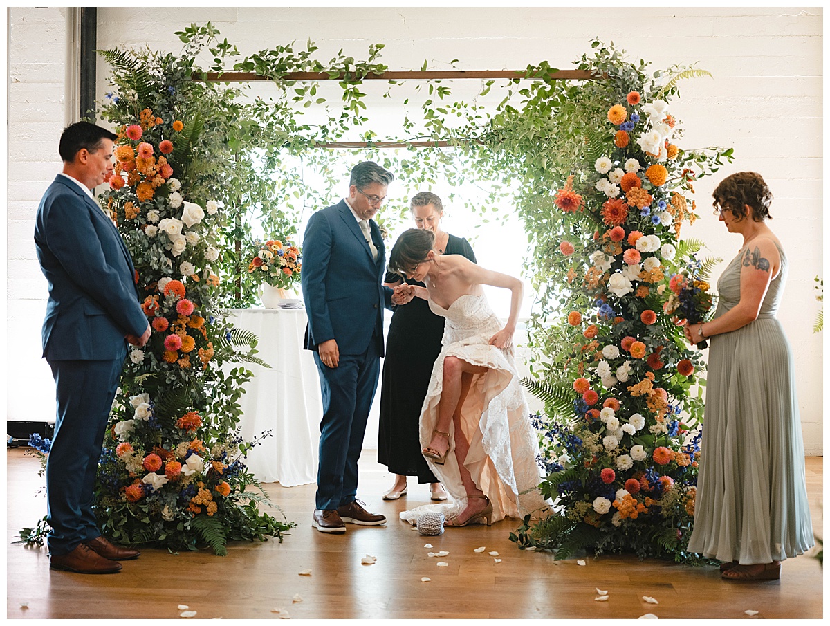 Bride prepares to break glass during the wedding ceremony, symbolizing the couple's union.