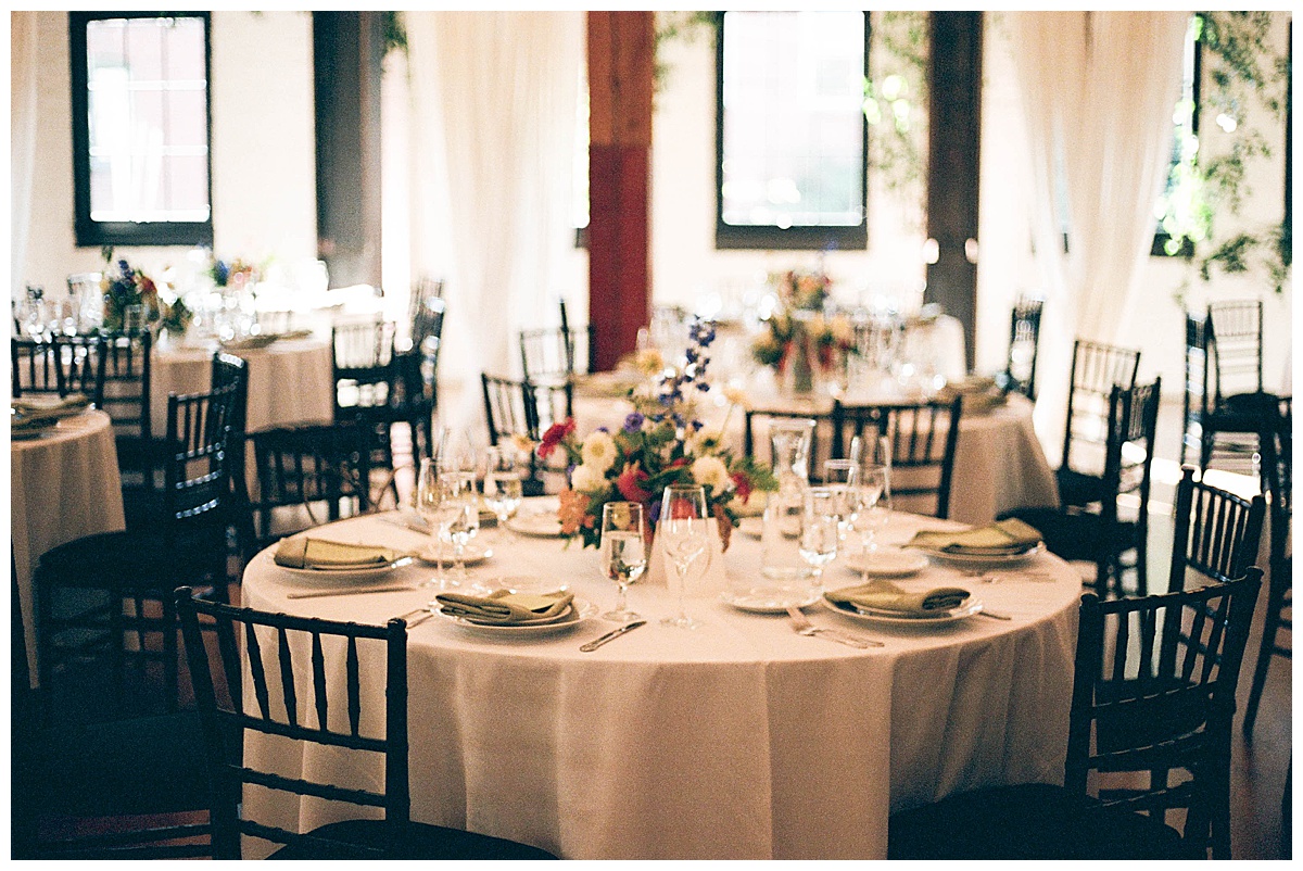 A beautifully set wedding table with floral centerpieces and elegant place settings, ready for the reception dinner.