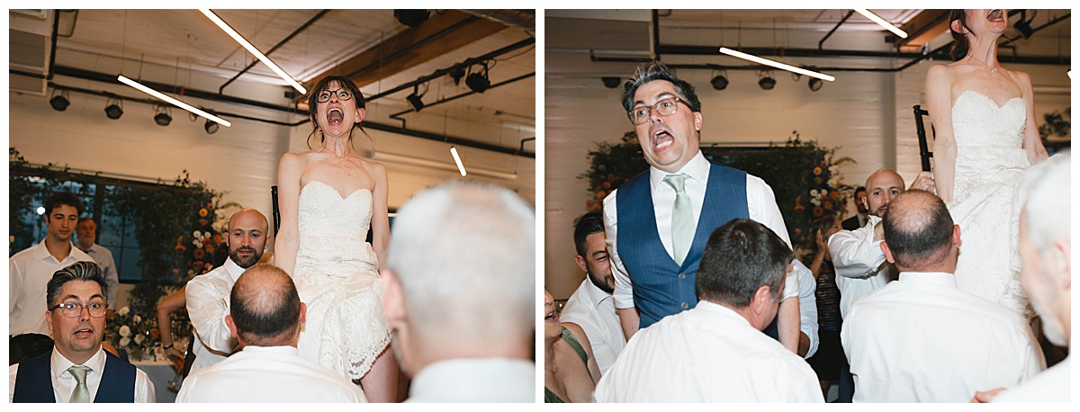 The bride and groom are lifted in chairs during the traditional hora dance, both laughing with joy.