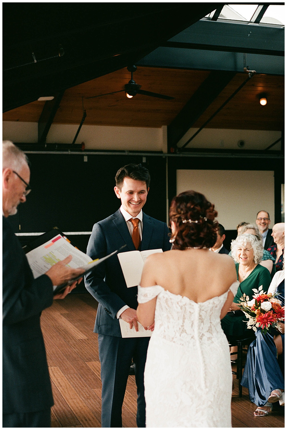 Groom smiling warmly as he exchanges vows with the bride during their ceremony at the Olympic Rooftop Pavilion.