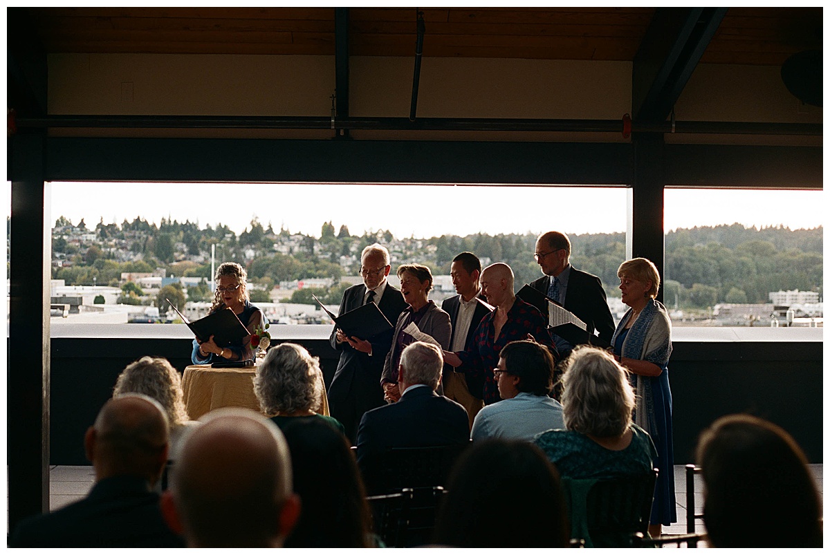 A choir of family and friends serenading the couple during their wedding ceremony at sunset.